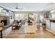 Cozy living room featuring a stone fireplace, open floor plan, hardwood floors, and ample seating at 6215 Barley Sq, Sugar Hill, GA 30518