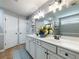 Spacious bathroom featuring double sinks, modern lighting fixtures, and a large mirror at 6215 Barley Sq, Sugar Hill, GA 30518