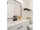 Bathroom featuring stylish vanity, sleek black fixtures, decorative mirror, and herringbone accent wall at 77 Township Drive, Hiram, GA 30141