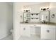 Bathroom with double vanity, modern fixtures, decorative mirrors, and patterned accent wall at 77 Township Drive, Hiram, GA 30141