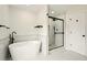 A modern bathroom with a soaking tub, glass-enclosed shower, and sleek fixtures at 77 Township Drive, Hiram, GA 30141