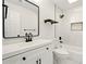 Bright bathroom featuring a black framed mirror, floating wood shelves, and tile backsplash in shower at 77 Township Drive, Hiram, GA 30141