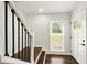 Inviting entryway features hardwood steps, black iron railing, and a bright view through the window at 77 Township Drive, Hiram, GA 30141