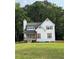Charming two-story house with white siding, black roof, and well-manicured front lawn at 77 Township Drive, Hiram, GA 30141