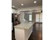 An open-concept kitchen featuring granite countertops, stainless steel appliances, and dark wood flooring at 77 Township Drive, Hiram, GA 30141