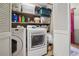 Functional laundry room with washer, dryer, storage shelves, and louvered doors at 2030 Spring End Ct, Lawrenceville, GA 30044
