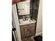 Bathroom featuring a wood vanity with a white sink, quartz countertop, modern fixtures, and dark accent tile at 2811 Country Farms Ct, Snellville, GA 30039