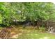 Backyard with a swing set, mature trees, and a wooden fence at 68 Paradise Pointe, Douglasville, GA 30134