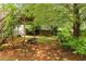 View of the backyard with a wooden pergola, bird bath, and foliage at 68 Paradise Pointe, Douglasville, GA 30134