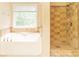 Bright bathroom featuring a soaking tub and walk-in shower with neutral tile at 68 Paradise Pointe, Douglasville, GA 30134