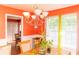 Traditional dining room with wooden table, chandelier, and bright orange walls at 68 Paradise Pointe, Douglasville, GA 30134