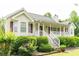 Charming home featuring a welcoming front porch and beautifully landscaped front yard with lush greenery at 68 Paradise Pointe, Douglasville, GA 30134
