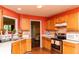 Well-lit kitchen featuring wood cabinets, stainless steel appliances, and tiled backsplash at 68 Paradise Pointe, Douglasville, GA 30134