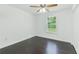 A well-lit room with dark hardwood floors, ceiling fan, and a window with a view of the outdoors at 9263 Club View Trce, Riverdale, GA 30274