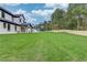 Expansive backyard featuring a lush lawn, a modern white home and a wood fence for privacy at 3205 Bold Springs Rd, Dacula, GA 30019