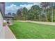 Expansive backyard with tall trees, wood fence, large grassy area, and covered patio at 3205 Bold Springs Rd, Dacula, GA 30019