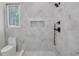 Bright bathroom featuring a marble-tiled shower, niche, modern fixtures, and a window offering natural light at 3205 Bold Springs Rd, Dacula, GA 30019
