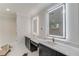 Modern bathroom with double vanity, white countertops, and large, lighted mirrors at 3205 Bold Springs Rd, Dacula, GA 30019
