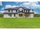 Back exterior view of home showcasing a well-manicured lawn, neutral siding, and modern black trim at 3205 Bold Springs Rd, Dacula, GA 30019