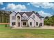 Striking two-story white brick home featuring a large, well-manicured front lawn and black trim details at 3205 Bold Springs Rd, Dacula, GA 30019