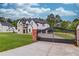 Elegant estate featuring a grand entrance gate and a sprawling green lawn that complements the home's architecture at 3205 Bold Springs Rd, Dacula, GA 30019