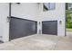 Close up of a two-car garage doors featuring black, modern doors and white painted brick at 3205 Bold Springs Rd, Dacula, GA 30019