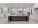 Spacious kitchen featuring a large center island, custom white cabinetry and designer pendant lighting at 3205 Bold Springs Rd, Dacula, GA 30019