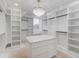 Spacious walk-in closet with custom shelving, a center island, and modern chandelier at 3205 Bold Springs Rd, Dacula, GA 30019
