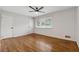 Spacious bedroom with hardwood floors, a ceiling fan, a window, and two doors at 346 Carpenter Dr # 77, Sandy Springs, GA 30328