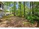 View of a large backyard with grass, mature trees, an AC unit, and a view of a neighboring home at 5181 Saint Claire Pl, Powder Springs, GA 30127
