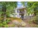 Backyard view of home with a wood fence, upper and lower level decks, and mature trees at 5181 Saint Claire Pl, Powder Springs, GA 30127