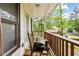A covered patio with a wooden railing and a view of the wooded backyard at 5181 Saint Claire Pl, Powder Springs, GA 30127