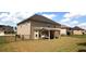 Spacious backyard featuring a covered patio, well-maintained lawn, and secure black metal fencing at 812 Graeme Dr, Mcdonough, GA 30252
