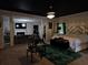 Open bedroom/living space with chandelier, bed, exercise equipment, and fireplace with television at 812 Graeme Dr, Mcdonough, GA 30252