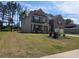Spacious two-story home with a lush lawn and mature trees on a sunny day at 812 Graeme Dr, Mcdonough, GA 30252