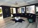 Spacious living room with modern lighting, a sleek black sectional sofa, and stylish decor at 812 Graeme Dr, Mcdonough, GA 30252