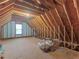 Spacious unfinished attic featuring plywood flooring, exposed rafters, and a window at 925 Champions Way, Mcdonough, GA 30252