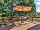 Enjoy outdoor dining on this wooden deck featuring a table, chairs, and umbrella at 925 Champions Way, Mcdonough, GA 30252