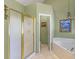 Bathroom with a shower and garden tub, a neutral color palette and a chandelier at 925 Champions Way, Mcdonough, GA 30252