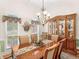 Formal dining area featuring a large window, chandelier, and decorative china cabinet at 925 Champions Way, Mcdonough, GA 30252