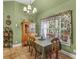 Traditional dining area featuring a wooden table set, classic chandelier, and decorative window treatment at 925 Champions Way, Mcdonough, GA 30252