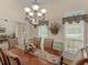 Well-lit dining room with a chandelier and views into the living room and entryway at 925 Champions Way, Mcdonough, GA 30252