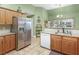 Bright kitchen with stainless steel refrigerator, wooden cabinetry, and granite countertops at 925 Champions Way, Mcdonough, GA 30252