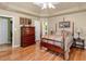 A beautiful main bedroom featuring a four-poster bed, hardwood floors, and access to the ensuite bath at 925 Champions Way, Mcdonough, GA 30252