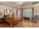 Spacious primary bedroom with tray ceiling, hardwood floors, and plenty of natural light at 925 Champions Way, Mcdonough, GA 30252