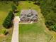 Stunning aerial view of a well-manicured lawn, mature trees, and a grand two-story home with a long driveway at 127 Grayson Myers Dr, Villa Rica, GA 30180
