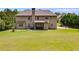 Wide-open backyard shows a spacious lawn, mature trees, and the home's rear facade at 127 Grayson Myers Dr, Villa Rica, GA 30180