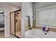 Bright bathroom with a glass-enclosed shower, soaking tub, and window, creating a refreshing and functional space at 127 Grayson Myers Dr, Villa Rica, GA 30180