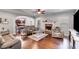 Bright living room showcasing a ceiling fan, fireplace, hardwood floors, and seamless flow into the kitchen at 127 Grayson Myers Dr, Villa Rica, GA 30180