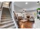 Inviting living room with a cozy brick fireplace, ceiling fan, hardwood floors, and staircase to the second floor at 127 Grayson Myers Dr, Villa Rica, GA 30180